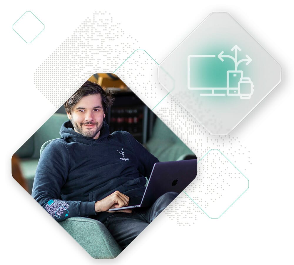 A person sits on a couch using a laptop, with a graphic overlay showing an icon of a desktop computer, tablet, and smartphone connected by arrows in the upper right corner, illustrating the seamless connectivity of IoT commerce.