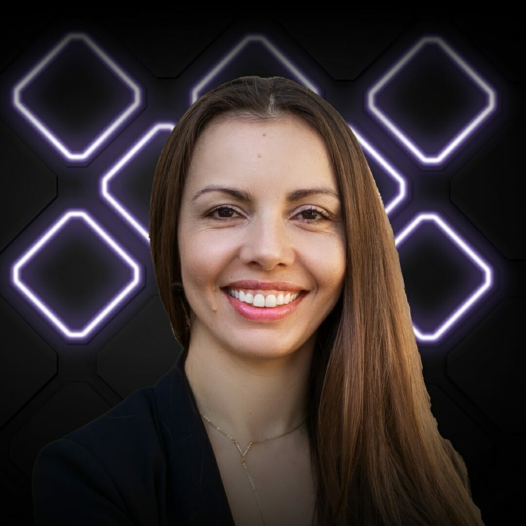 A smiling woman with long, straight hair stands in front of a dark background featuring illuminated geometric shapes, capturing the energetic vibe of EXCITE 2022 Nashville.